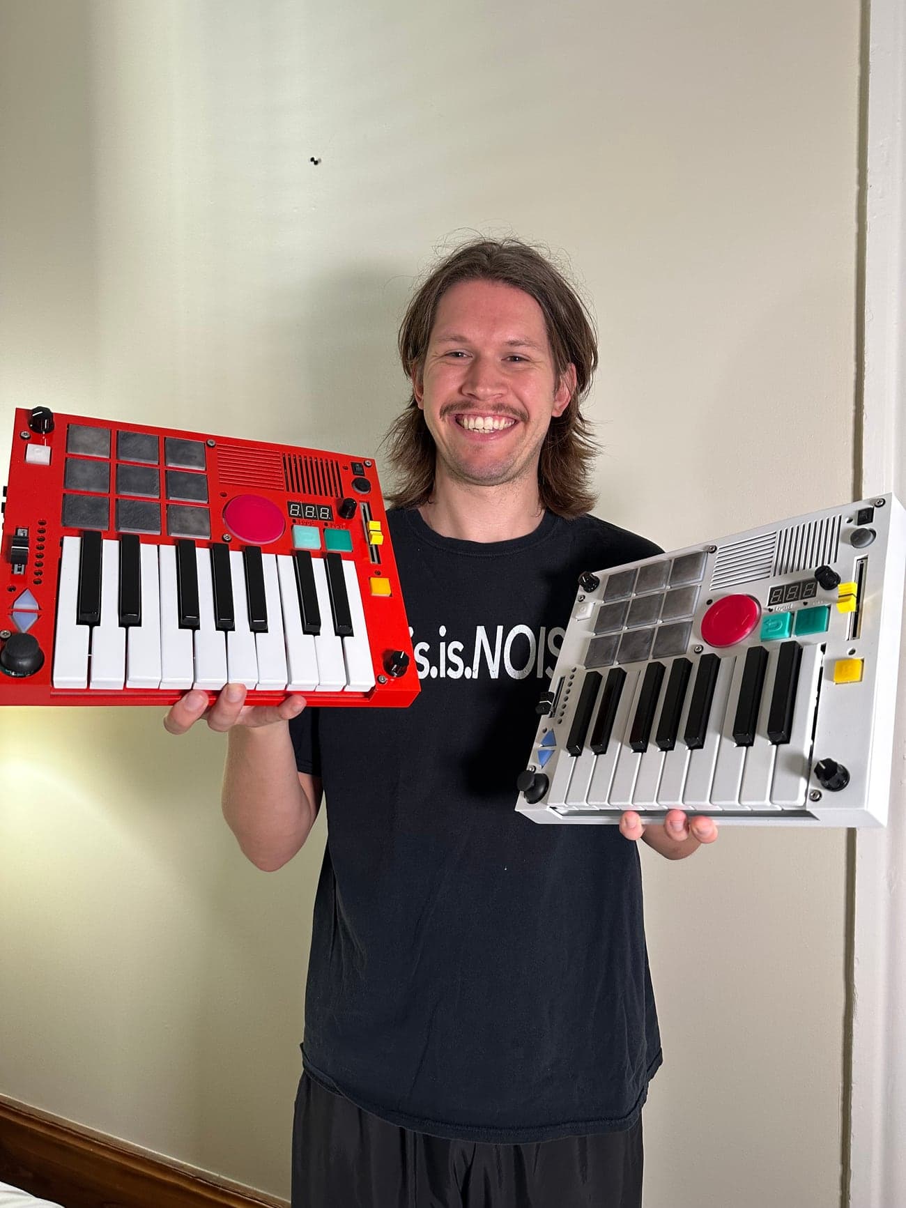 Connor, the maker of The Beat Brick, holding two machines