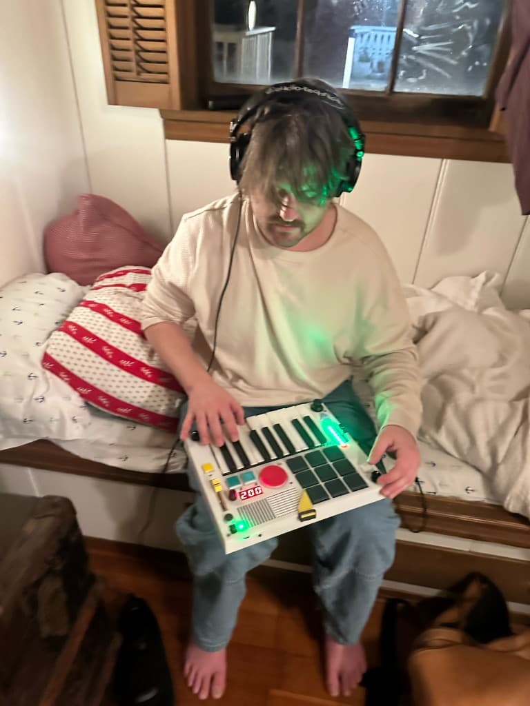 Playing The Beat Brick with headphones while sitting on a bed