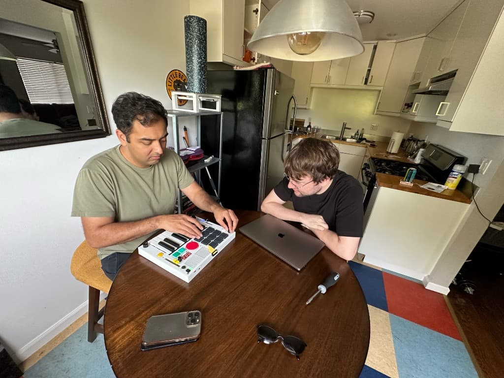 Showing The Beat Brick to a friend at a kitchen table